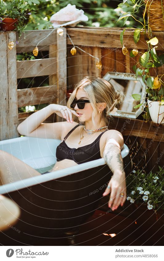Frau in der Badewanne auf der Veranda Wasser patio Hautpflege Terrasse Wohlbefinden Kälte Routine Stil Sonnenbrille Vorschein feminin ruhen Sommer charmant Dame