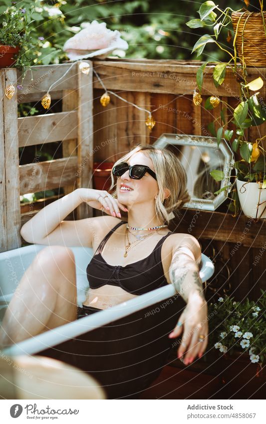 Frau in der Badewanne auf der Veranda Wasser patio Hautpflege Terrasse Wohlbefinden Kälte Routine Stil Sonnenbrille Vorschein feminin ruhen Sommer charmant Dame