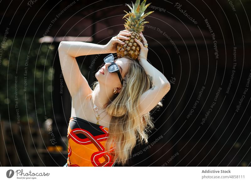 Frau mit Ananas auf dem Kopf Terrasse Stil Frucht gesunde Ernährung Sonnenbrille exotisch tropisch natürlich Vitamin trendy Gebäude Sommer reif organisch frisch