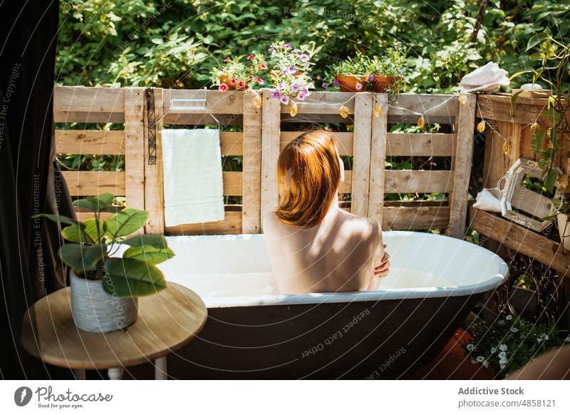 Unbekannte Frau sitzt in der Badewanne Wasser patio Hautpflege Terrasse Wohlbefinden Routine oben ohne Kälte Stil Vorschein Rotschopf Kübel ruhen Waschen Sommer