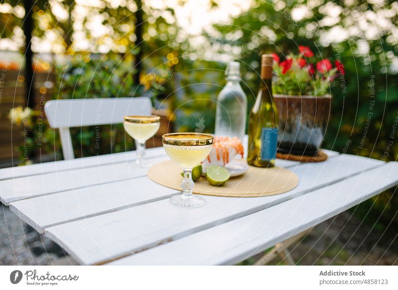 Champagnergläser auf dem Tisch mit Krabben Glas Granele Meeresfrüchte Alkohol Terrasse patio Hinterhof Landschaft Schnaps Aperitif Flasche dienen trinken