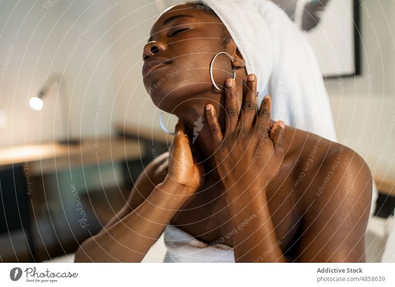 Schwarze Frau trägt Creme auf den Hals auf bewerben Sahne Hautpflege Abend heimwärts Bett Feuchtigkeit Schönheitsprogramm Sauberkeit Spa jung schwarz