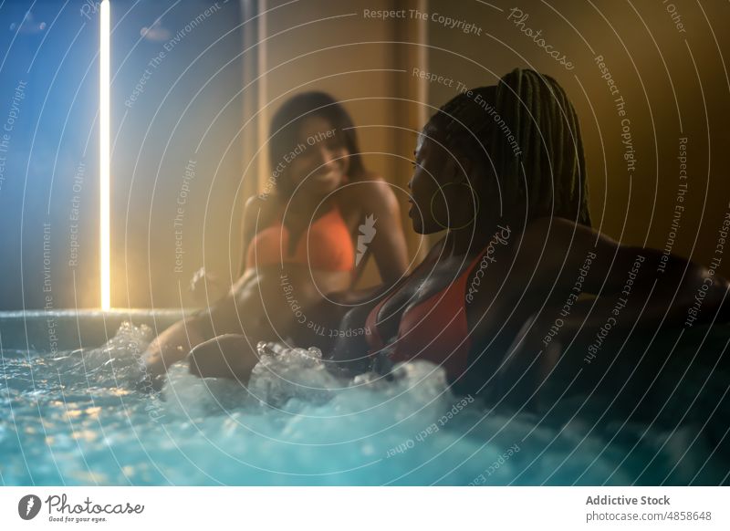 Schwarze Frauen sitzen im Whirlpool Freund Spa Heißes Bad Wasser Wohlbefinden Verfahren Hautpflege Körperpflege Kälte trendy feminin Wellness Afroamerikaner