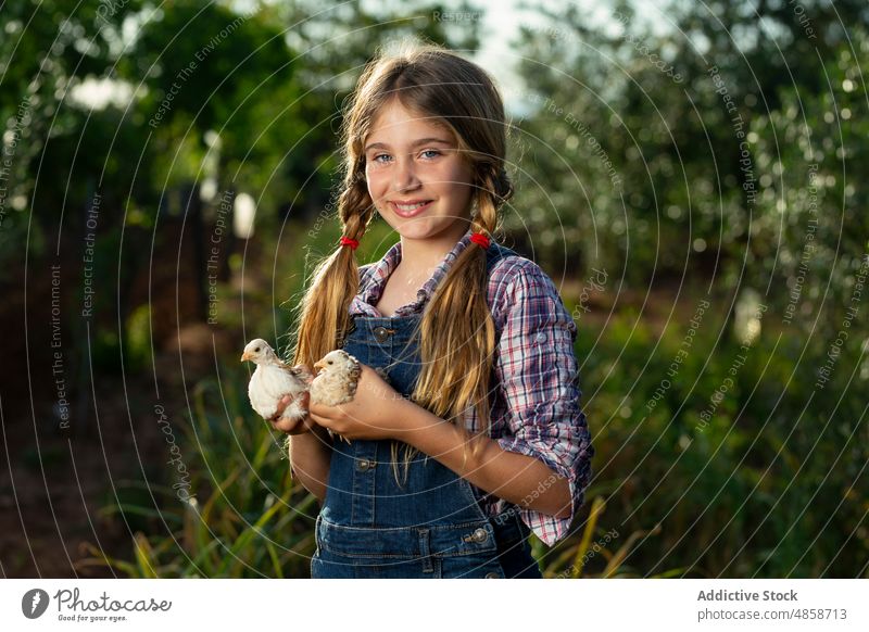 Optimistisches Mädchen mit Küken auf dem Bauernhof Landwirt Landschaft Lächeln Sommer Tier positiv Porträt tagsüber Kind lässig führen heiter Glück ländlich