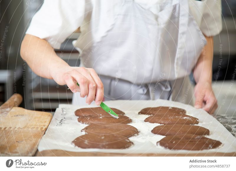 Anonymer konzentrierter Bäcker bei der Zubereitung von Keksen in einer Bäckerei Frau Gebäck Dessert kulinarisch Teigwaren süß roh Küche Arbeit Industrie Job