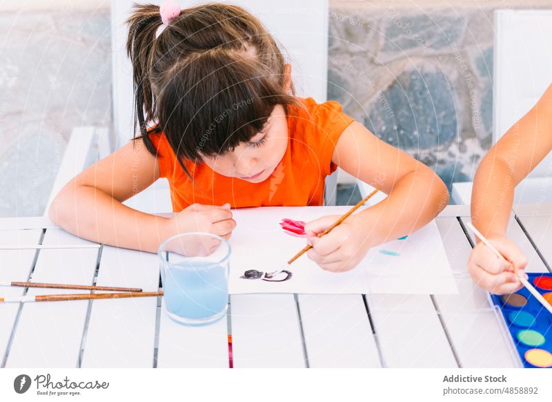 Mädchen malt auf Papier auf Terrasse Kind Farbe Hobby Kunst Vorstellungskraft Kindheit Zeitvertreib Vorrat Handwerk Pinselblume kreativ farbenfroh üben