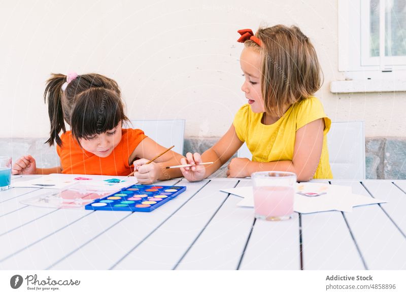 Niedliche Mädchen malen mit Aquarellfarben Kinder Farbe Hobby Kunst Terrasse Papier Wasserfarbe Kindheit Phantasie Vorrat Straße Vorstellungskraft Handwerk