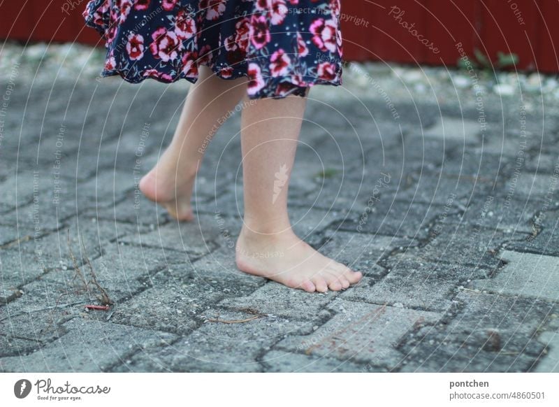 Nackte Kinderbeine und Füße auf Pflastersteinen. Mädchen im Sommer in Bewegung. pflastersteine bewegung füße Kleid Lebensfreude spielen Kindheit Fröhlichkeit