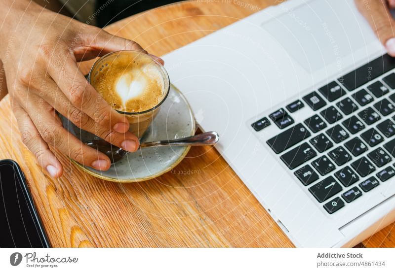 Anonymer junger Mann mit Laptop in einem Cafe Café freiberuflich trinken Kaffee Arbeit abgelegen modern Netbook Gerät Kopfhörer ethnisch lässig männlich Getränk