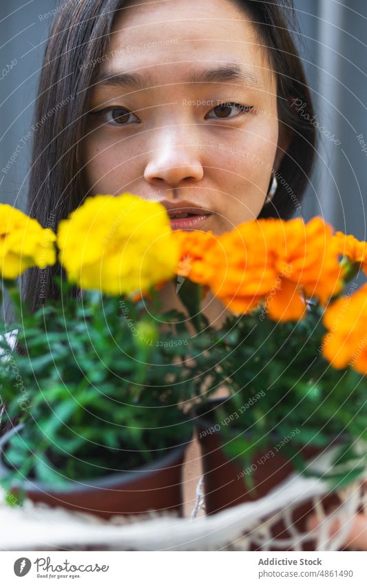 Asiatische Frau mit Ringelblumenblüten in Töpfen Blume Blumentopf Markt geblümt Kunde eingetopft Blütezeit farbenfroh Laden Netzbeutel Pflanze Wahl asiatisch
