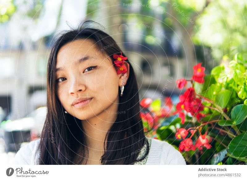 Charmante asiatische Frau mit Blumen im Haar Behaarung Porträt Vorschein Straße geblümt Blütenknospen charmant Sommer Pflanze feminin Stil natürlich ethnisch