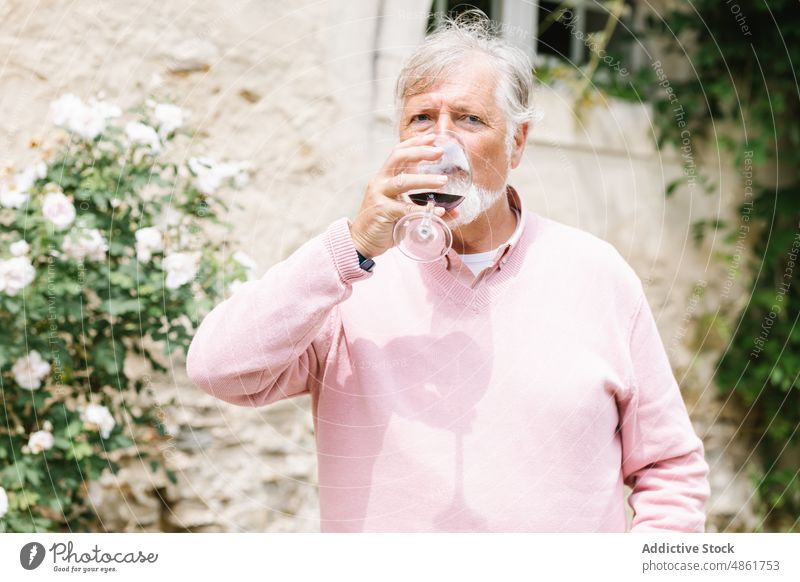 Älterer Mann trinkt Wein während einer Hochzeitsfeier Senior reif Rotwein Alkohol trinken feiern Veranstaltung Anlass festlich Vollbart Party Getränk älter