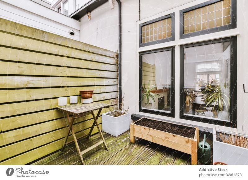 Holzterrasse einer modernen Wohnung bei Tageslicht Terrasse Appartement Tisch Pflanze Dekor wohnbedingt Gebäude Großstadt gemütlich Topf Möbel Balkon Design