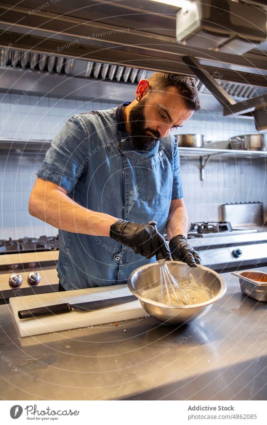 Chefkoch schlägt Mehl in einer Schüssel in der Küche Küchenchef auspeitschend Mischen Schalen & Schüsseln Abfertigungsschalter Restaurant Schneebesen Teigwaren