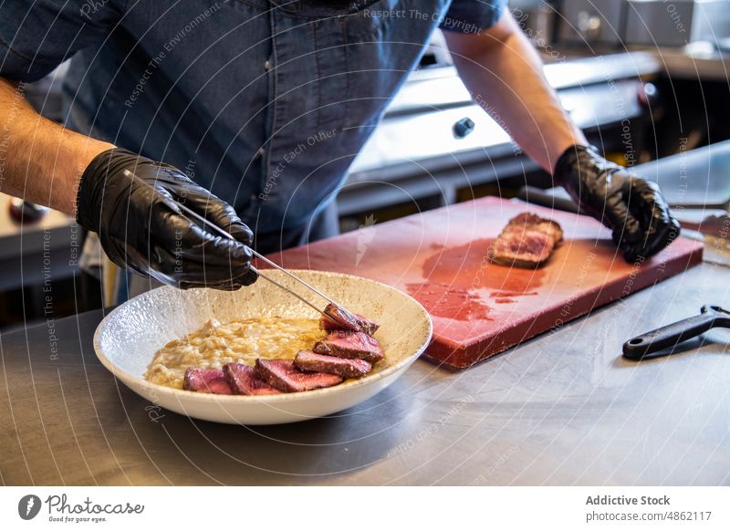 Chefkoch platziert Steakscheiben in einer Schüssel auf dem Tresen im Restaurant Küchenchef Platzierung Scheibe Schalen & Schüsseln Abfertigungsschalter Speise