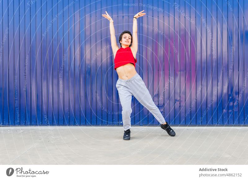 Frau tanzt in der Nähe der blauen Wand Tänzer Tanzen sportlich Straße Hobby Großstadt üben Probe Choreographie Stil Energie lässig Gesunder Lebensstil Stadt