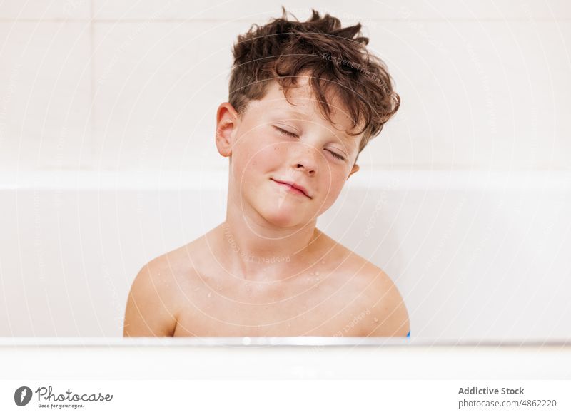 Junge mit geschlossenen Augen in der Badewanne sitzend Kind geschlossene Augen Hygiene Routine schlafen Porträt Sauberkeit täglich Kindheit sorgenfrei zu Hause