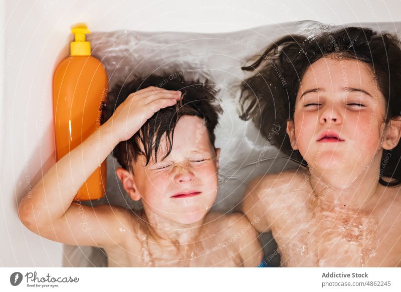 Kinder baden gemeinsam zu Hause Bad Zusammensein Bruder Schwester Bonden Badewanne Augen geschlossen Hygiene Geschwisterkind Lügen weiß ruhen