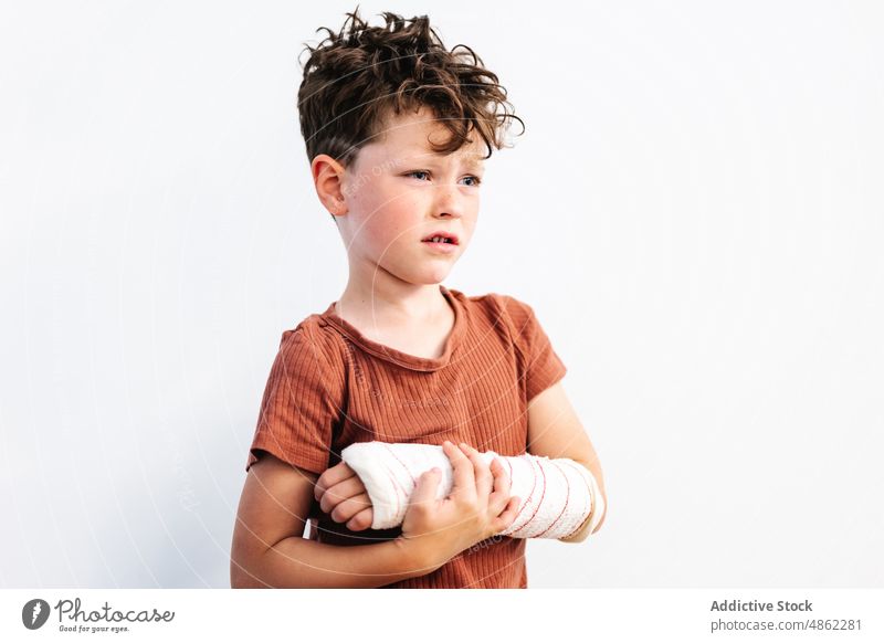 Unglücklicher Junge mit gebrochenem Arm in Gipsbandage verärgert bandagieren Verletzung verputzen geduldig Schmerz wehtun Halt frustrieren unglücklich Unbehagen