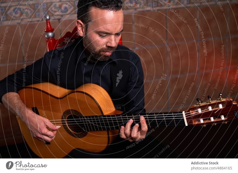 Bärtiger Mann spielt ein Lied auf der Gitarre Gitarrenspieler spielen Musiker Gesang Instrument Hobby akustisch üben Talent männlich Fähigkeit ausführen Melodie
