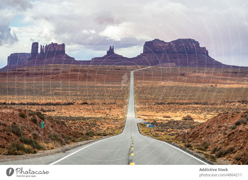 Landschaftlich reizvoller Berg zwischen asphaltierten Autobahnen Klippen Utah Arizona Nationalpark Straße Asphalt Monument Valley Fahrbahn wolkig reisen