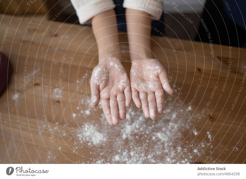 Draufsicht auf ein Mädchen, das Hände mit Mehl zeigt zeigend Hand Arbeitsplatte Herstellung heimwärts bedeckt Bestandteil unordentlich lernen Handfläche spielen