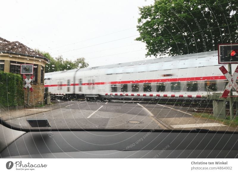 Der Zug hat Vorfahrt / warten an der geschlossenen Bahnschranke fahrender Zug Eisenbahn Bahnfahren Öffentlicher Personennahverkehr Personenzug Verkehrswege