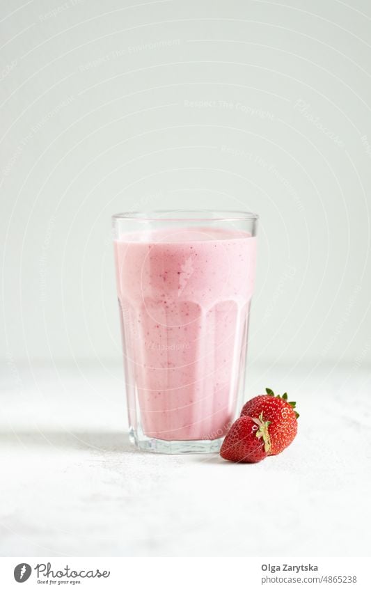 Erdbeer-Smoothie im Glas. Milchshake Erdbeeren weiß Tisch Beeren rosa rot melken kalt Sommer abschließen Selektiver Fokus trinken schütteln Entzug gemischt