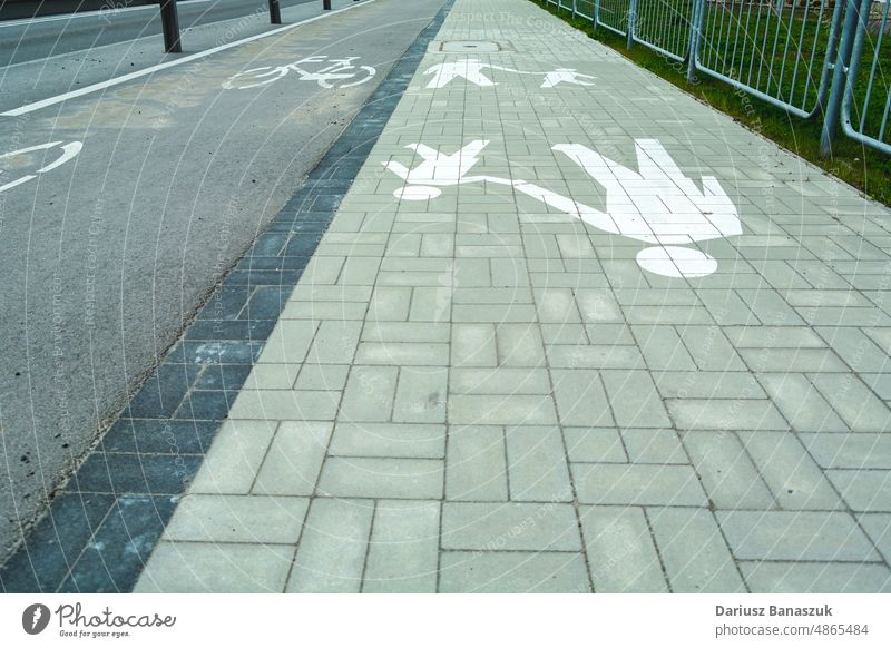 Radweg neben dem Fußweg und horizontale Warnschilder Fahrrad Straße Asphalt Zeichen Verkehr Fußgänger Symbol Sicherheit Weg Transport Zyklus Fahrspur weiß Linie
