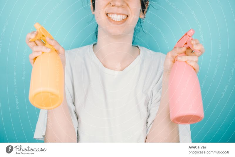 Junge Frau lächelt fröhlich in die Kamera, während sie ein Paar Wassersprüher hält, um sich im Sommer zu erfrischen. Urlaub im Freien mit Kopie Raum.Farbe Hintergrundbild