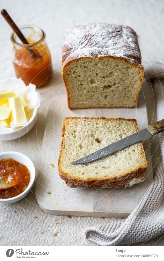 Knuspriges Brot mit Butter und Aprikosen Konfitüre auf einem Leinen Tischtuch Frühstück Marmelade knusprig süß Essen frisch gebacken tischtuch Teller Messer