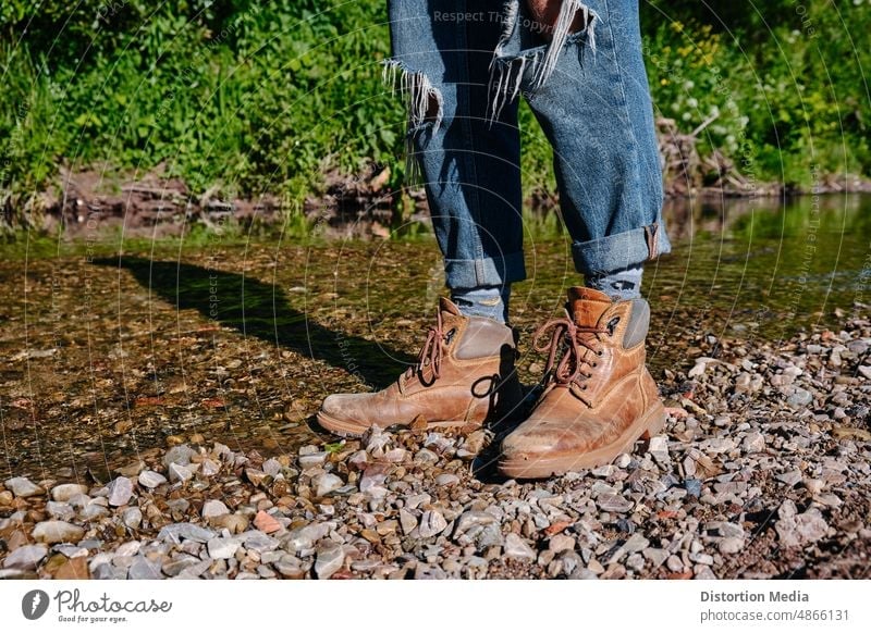 Füße eines Wanderers mit Stiefeln am Ufer eines Flusses, bereit, seine Reise fortzusetzen aktiv Aktivität Abenteuer Herbst Backpacker Klettern Nahaufnahme