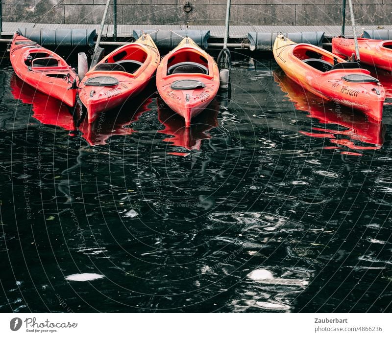 Rote Kajaks auf dunklem Wasser rot wellen dunkel spiegeln See Reflexion & Spiegelung Wasseroberfläche Wasserspiegelung Hafen Sportboot Wassersport paddeln