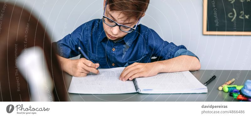 Teenager schreibt in Notebook in der Schule Schüler Klassenraum schreibend konzentriert Bildung Transparente Netz Kopfball Panorama panoramisch Textfreiraum