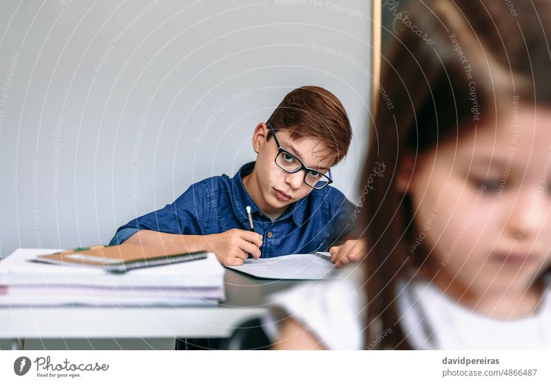 Teenager schreiben in Notebook in der Schule Schüler schauende Kamera Klassenraum schreibend klug fleißig Bildung Menschen jung Junge Mädchen Frau zwei Person