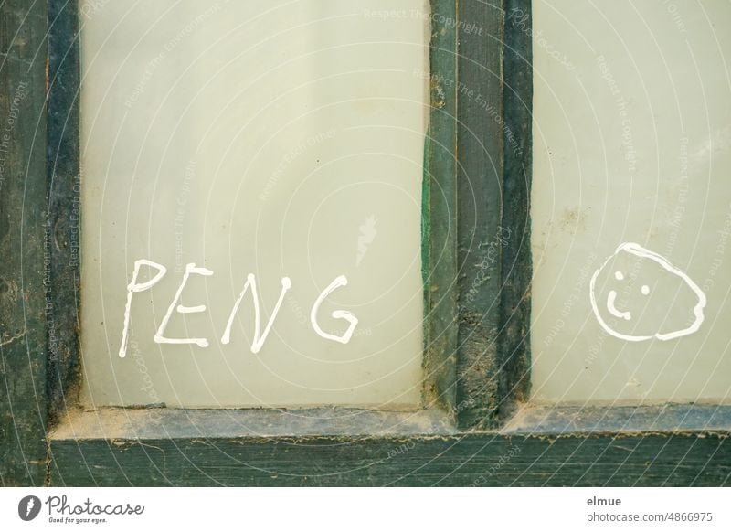 PENG und ein Mondgesicht sind in weißer Farbe an die Glasscheibe eines grünen Holzfensters gemalt peng smiley Smiley-Gesicht Fenster Fensterscheibe Schmiererei