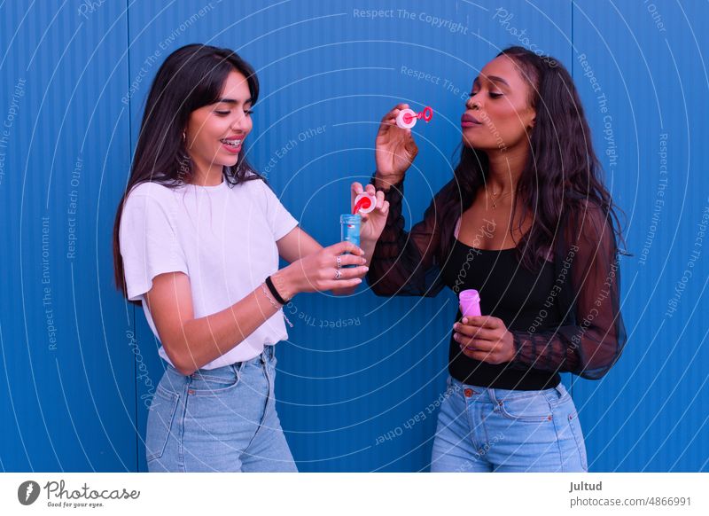 Zwei Freunde haben Spaß beim Seifenblasenmachen Mädchen Ethnizität Spanien jung Frau Zwanziger Jahre trendy Gebäudeaußenseite Freundin Freundschaft