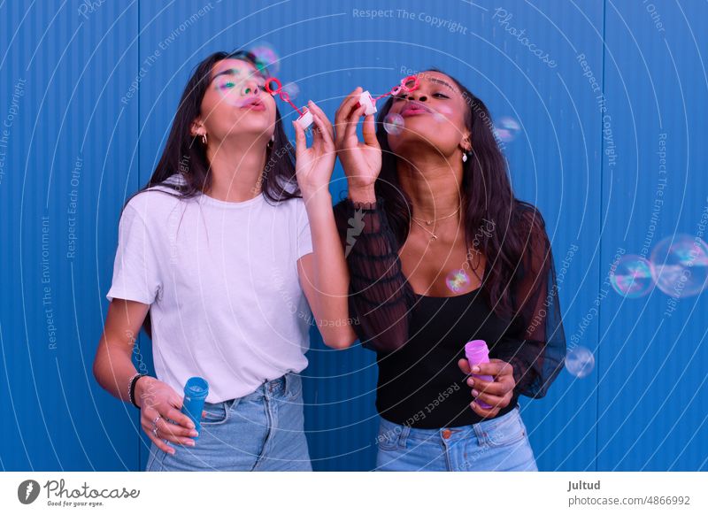 Zwei Freunde haben Spaß beim Seifenblasenmachen Mädchen Ethnizität Spanien jung Frau Zwanziger Jahre trendy Gebäudeaußenseite Freundin Freundschaft
