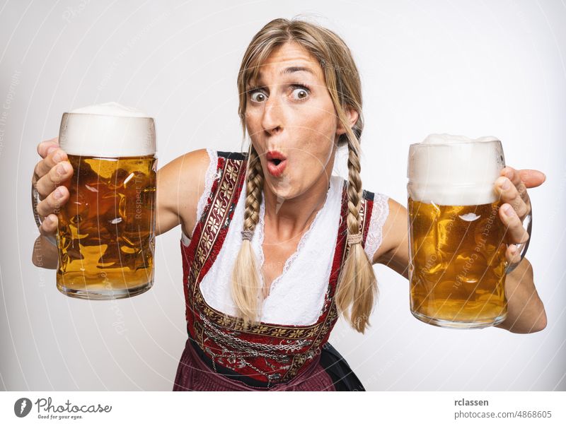 sexy traditionelle Oktoberfestbesucherin in traditioneller bayerischer Tracht und mit großen Bierkrügen in der Hand im Herbst in Deutschland Mädchen trinken