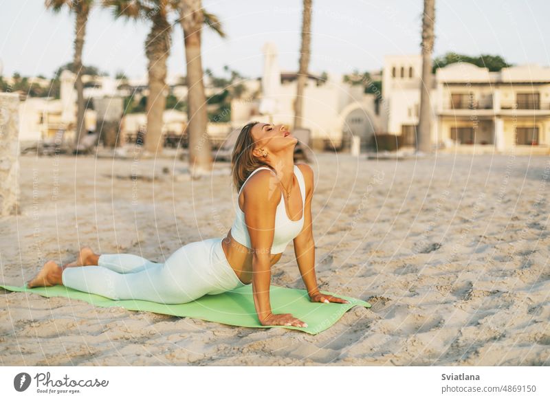 Ein junges Mädchen praktiziert Yoga am Strand. Sport, Fitness, Yoga. Das Konzept der Pflege und gesunden Lebensstil Frau schön Sommer Meer Sonnenuntergang