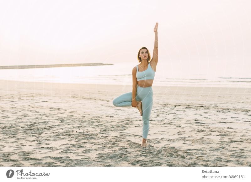 Ein schlankes Mädchen praktiziert Yoga am Strand bei Sonnenuntergang, führt Asanas aus Frau jung schön Sommer Meer Seeküste Feiertag reisen praktizieren Urlaub