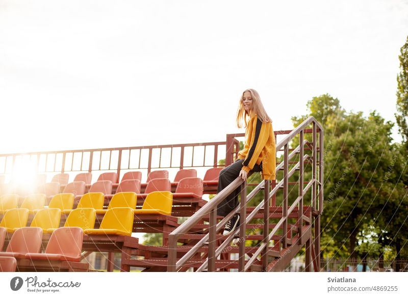 Ein junges Mädchen hat Spaß und rutscht das Geländer im Stadion hinunter Reling Treppe Mitfahrgelegenheit schön cool Sliden spielen Teenager Treppenhaus