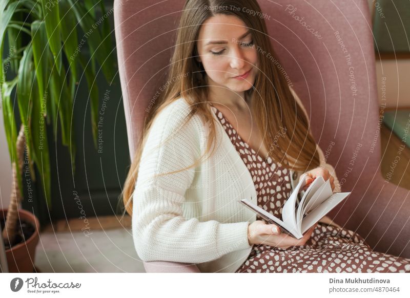 Person beim Lesen eines Buches in der Bibliothek. Junge Frau liest Bücher, studiert in der Universitätsbibliothek, oder Coworking Space, Büro oder zu Hause. Zurück zu Schule Konzept.
