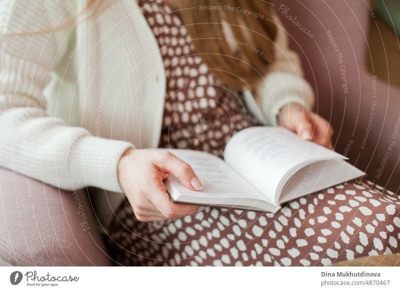Person beim Lesen eines Buches in der Bibliothek. Junge Frau liest Bücher, studiert in der Universitätsbibliothek, oder Coworking Space, Büro oder zu Hause. Zurück zu Schule Konzept.