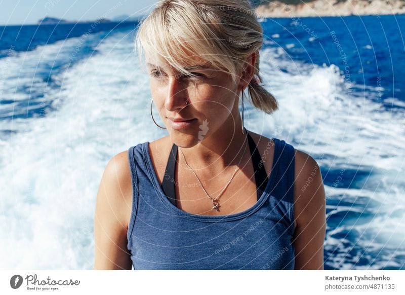 Blondes Mädchen segelt auf einem Boot im heißen Sommer sonnigen Tag auf ihre Berufung weit von zu Hause Abenteuer-Reisen Hintergrund schön blondes Haar blau