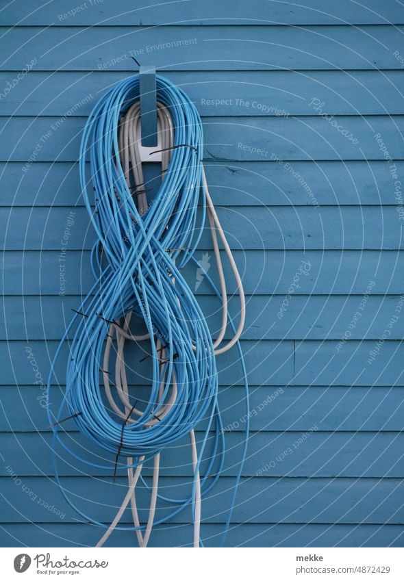 Eine blaue Acht versteckt sich - oder sind es doch mehr Zahl 8 Stromkabel Kabel Elektrizität Energie Energiewirtschaft Energiekrise Energie sparen Haus Hauswand