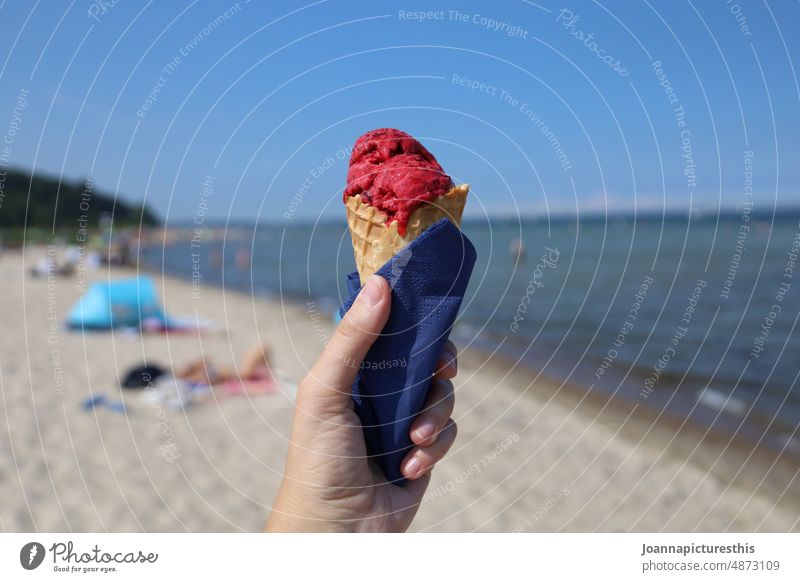 Himbeereis in Waffel in Hand am Strand Eis Sommer Speiseeis Lebensmittel süß Ernährung Erfrischung lecker Dessert