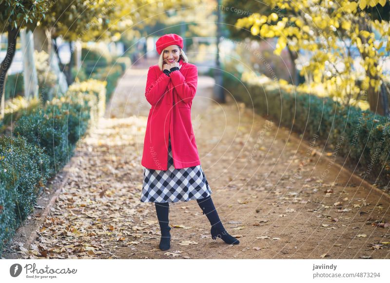 Modische Frau im herbstlichen Park Straße Stil Mode feminin Design elegant Weg Herbst fallen Laufsteg Laubwerk Outfit Stadt rot Dame anhaben Baskenmütze Mantel