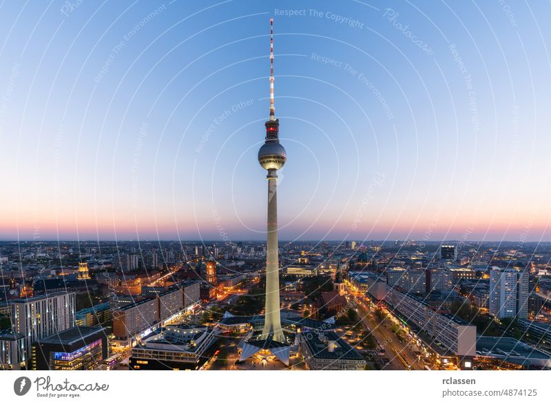 Luftaufnahme der Berliner Skyline mit dem berühmten Fernsehturm am Alexanderplatz und dramatischen Wolken in der Dämmerung während der blauen Stunde, Deutschland