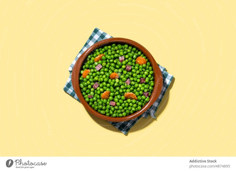 Grüne Erbsen mit Serranoschinken und Karotte auf gelbem Hintergrund grün Möhre Schinken Gemüse Gesundheit mischen Abendessen Lebensmittel Mittagessen Spanisch